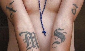 An MS-13 member in Washington displays his gang tattoos