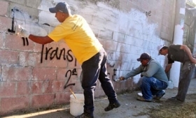 Gang members, government workers clean graffiti outside San Salvador