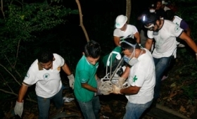 El Salvador police remove the body of a murder victim