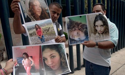 Family members hold images of Heaven victim