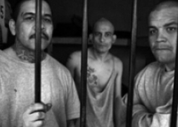 Members of the Barrie Azteca stand behind prison bars