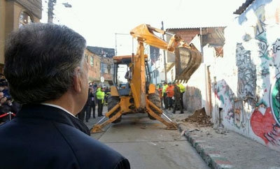 Santos watches as "ollas" are demolished