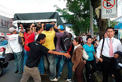 Salvadorans climb onto a pickup truck during the bus strike