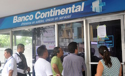 Clients gather outside a closed Banco Continental branch