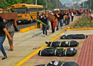 Marchers walk past body bags in Honduras