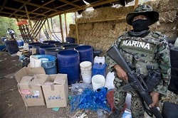 A Mexican soldier stands guards in front of a seized synthetic drug lab in Sinaloa.