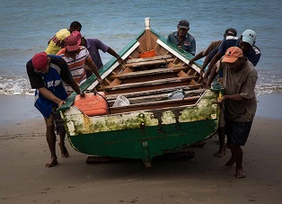 Fisherman bringing their boat ashore on Venezuelaâs Caribbean coast
