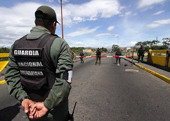 A member of Venezuelaâs National Guard watches over a border crossing with Colombia