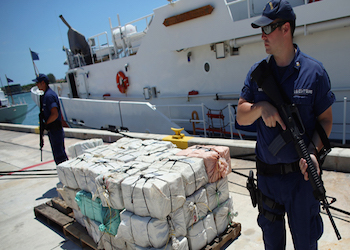 Authorities guard a cocaine shipment seized in Caribbean waters