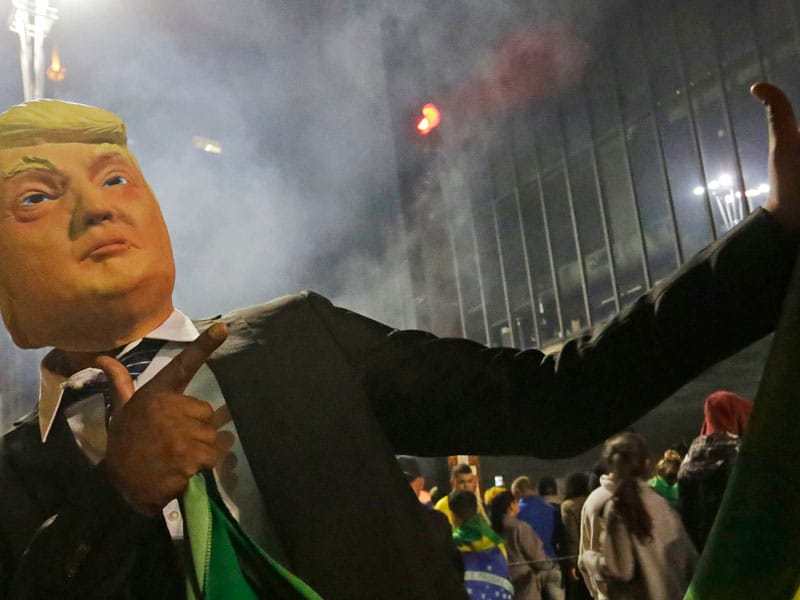 Image: Supporter of president Jair Bolsonaro wears a trump mask