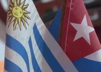 Two flags side by side, one of Uruguay on the left, one of Cuba on the right