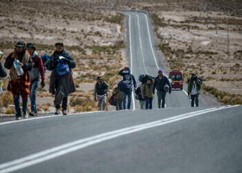 Venezuelan migrants are seen walking along a road linking Bolivia and Chile