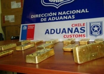 Gold bars lie on a table, being presented by Chile customs
