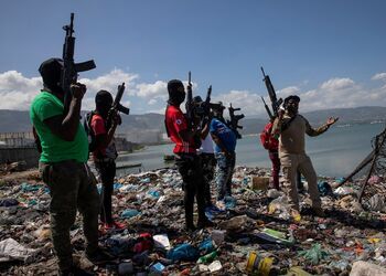 Haiti gang leader, Barbecue, stands with his men, holding rifles, outside Terminal Varreux