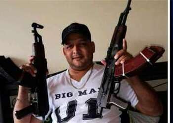 A photo of Alejandro Arias Monge, alias “Diablo”, a Costa Rican gangster, holding two automatic rifles