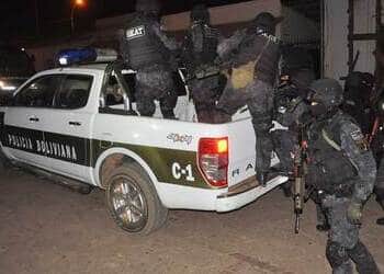 Varios policías bolivianos salen de una camioneta blanca de la policía en San Matías