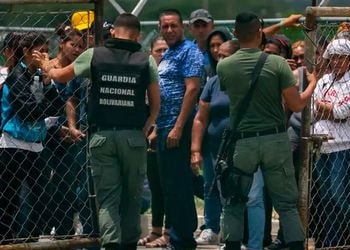 Families wait outside a Venezuelan prison for news of their loved ones after a riot