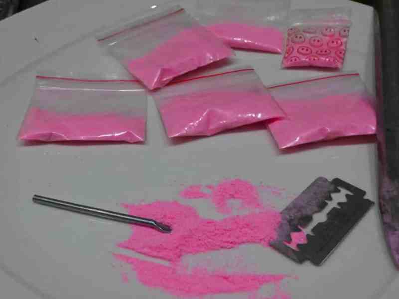 Seven packets of Tusi. or pink cocaine, spread out on a table.