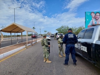 Policías patrullando vía de Sonora tras el hallazgo de cuatro cuerpos