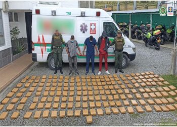 Three occupants of a narco ambulance arrested in Nariño, Colombia stand in front of the marijuana they were transporting