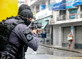 Policía apunta su rifle contra una mujer en una calle en Río de Janeiro
