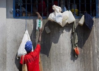 Haitian prisoners grasping for food