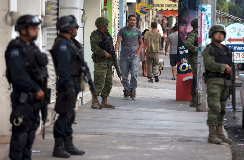Federal police and soldiers stand guard in Apatzingan, Michoacan, Mexico