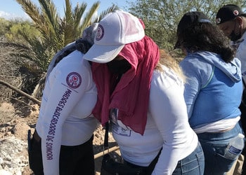 Two mothers hug in Mexico's state of Sonora after finding a mass grave.