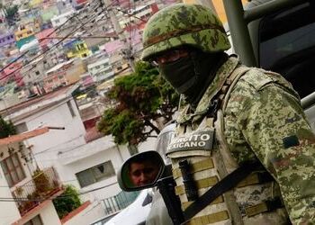 An army soldier watches over a town in Mexico