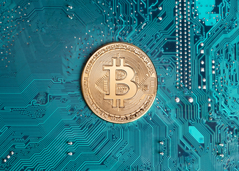 Golden bitcoin replica on computer circuit board. This file is cleaned and retouched.