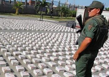 A Venezuelan soldier stands guard over cocaine seized in July 2022