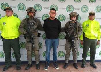 Wilder Emilio Sánchez Farfán, alias “Gato Farfán” poses with Colombian authorities who captured him in Pasto, Narino