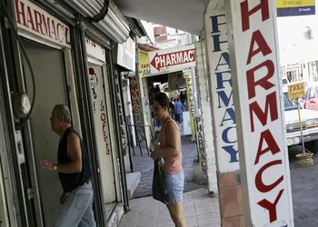 Customers wait outside a pharmacy in Mexico.