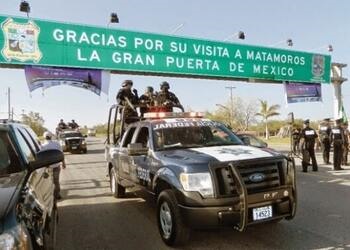 Varios oficiales de policía se encuentran en una camioneta mientras custodian el paso fronterizo de Matamoros con Estados Unidos
