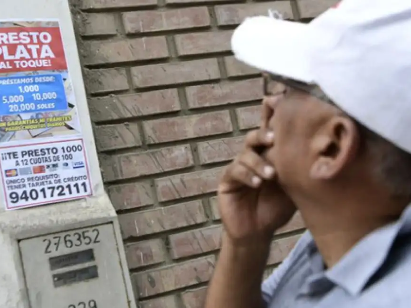 A passer-by in Peru reads an advertisement for a loan. Un transeúnte en Perú lee un anuncio de préstamos gota a gota. Ministerio del Interior de Perú