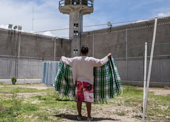 A woman in prison in Mexico hangs a blanket to dry