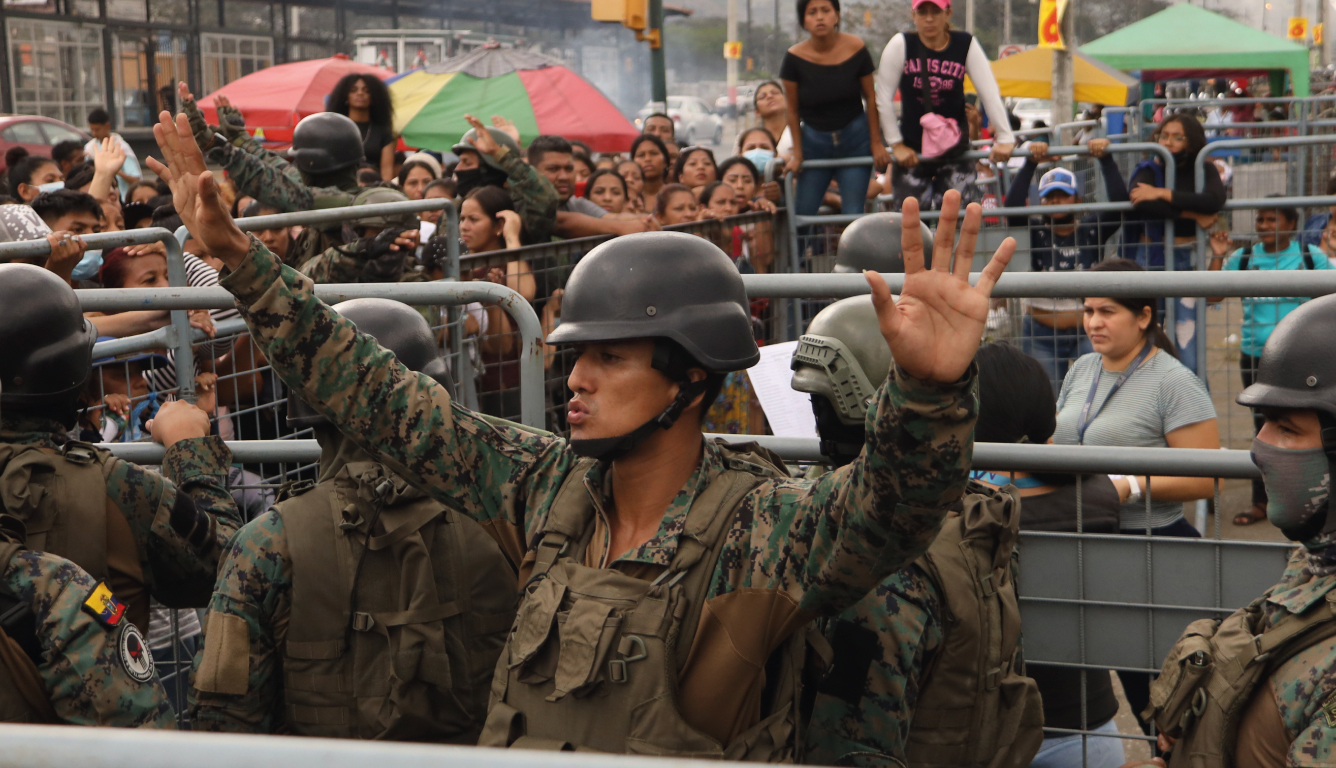 Soldiers try to calm down a crowd after a prison massacre in Ecuador in July 2023.