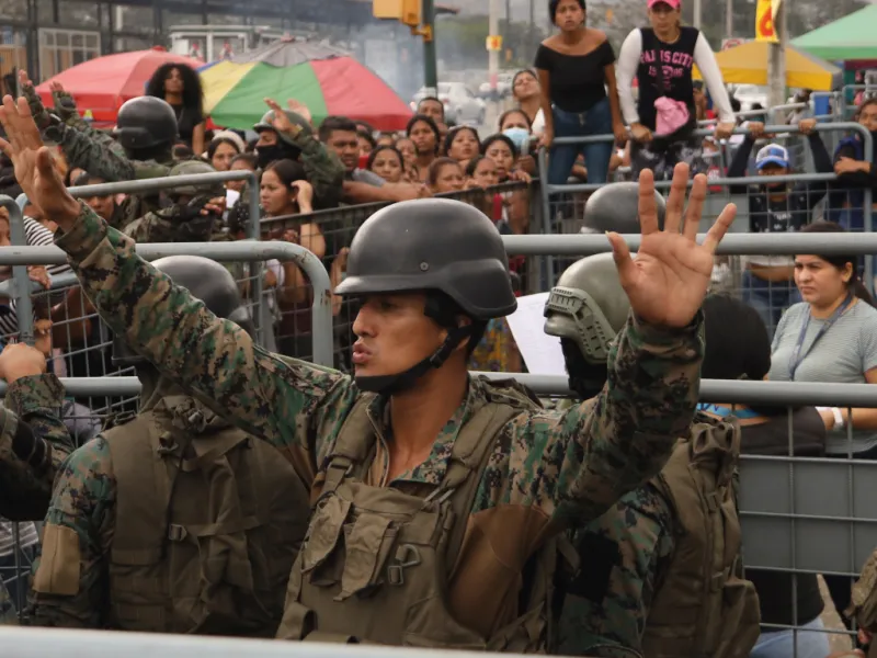 Soldiers try to calm down a crowd after a prison massacre in Ecuador in July 2023.