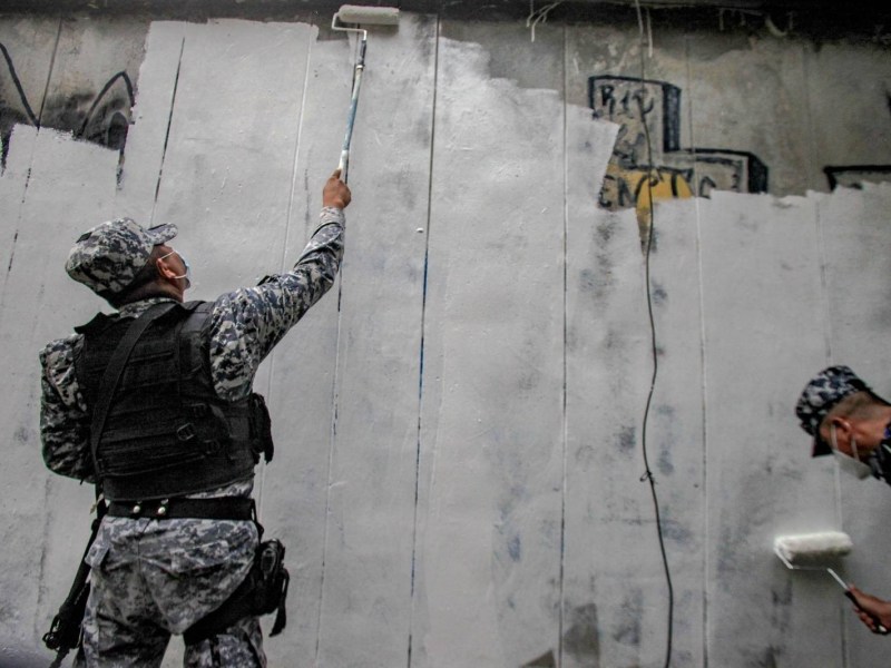 Salvadoran security forces whitewashing a wall.