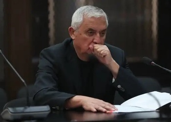 Former Guatemala president Otto Pérez Molina covers his mouth as he sits in court.