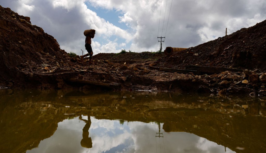 A Venezuelan miner carries rocks to a grinding mill in Venezuela's