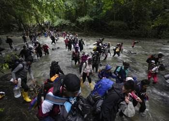 People walking through the muddy jungle of the Darien Gap, one of the routes most used by irregular migrants.