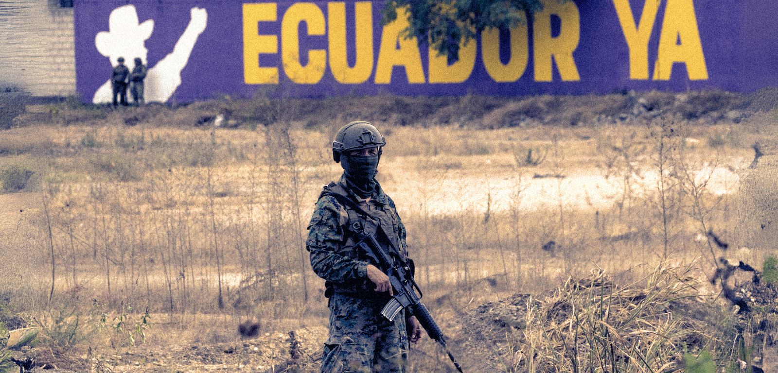 A soldier stands in front of an electoral poster for President Daniel Noboa.