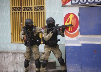 Police take cover during a gun battle in Port-au-Prince, Haiti. La policía se cubre durante un tiroteo en Puerto Príncipe, Haití.