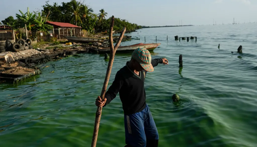 A fisherman walks along the shores of Lake Maracaibo.