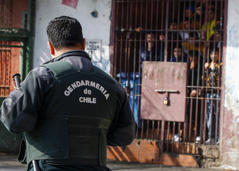 A Gendarmerie officer guards a crowded Chilean prison. Un oficial de la Gendarmería custodia una abarrotada prisión en Chile