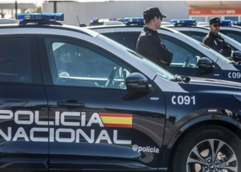 Police officers pose next to a seized stash of cocaine in Spain. Agentes de policía posan junto a un alijo de cocaína incautada en España.